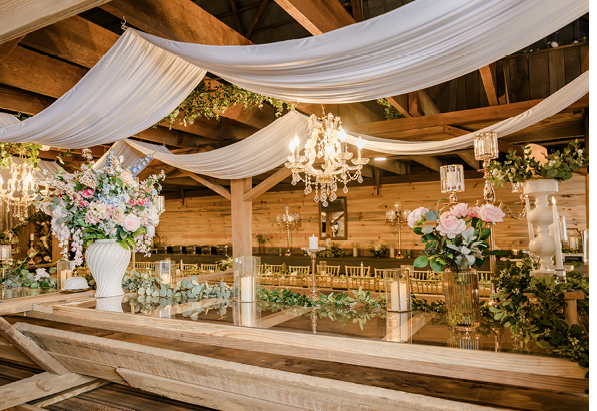 Fabric ceiling drapes, string lights, chandeliers and flowers